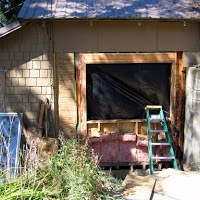 A picture shortly after we had started the project. The old window is on the leaning against the house (left). We ended up re-framing this wall so that a larger window could be installed and to take care of the studs the termites ate.